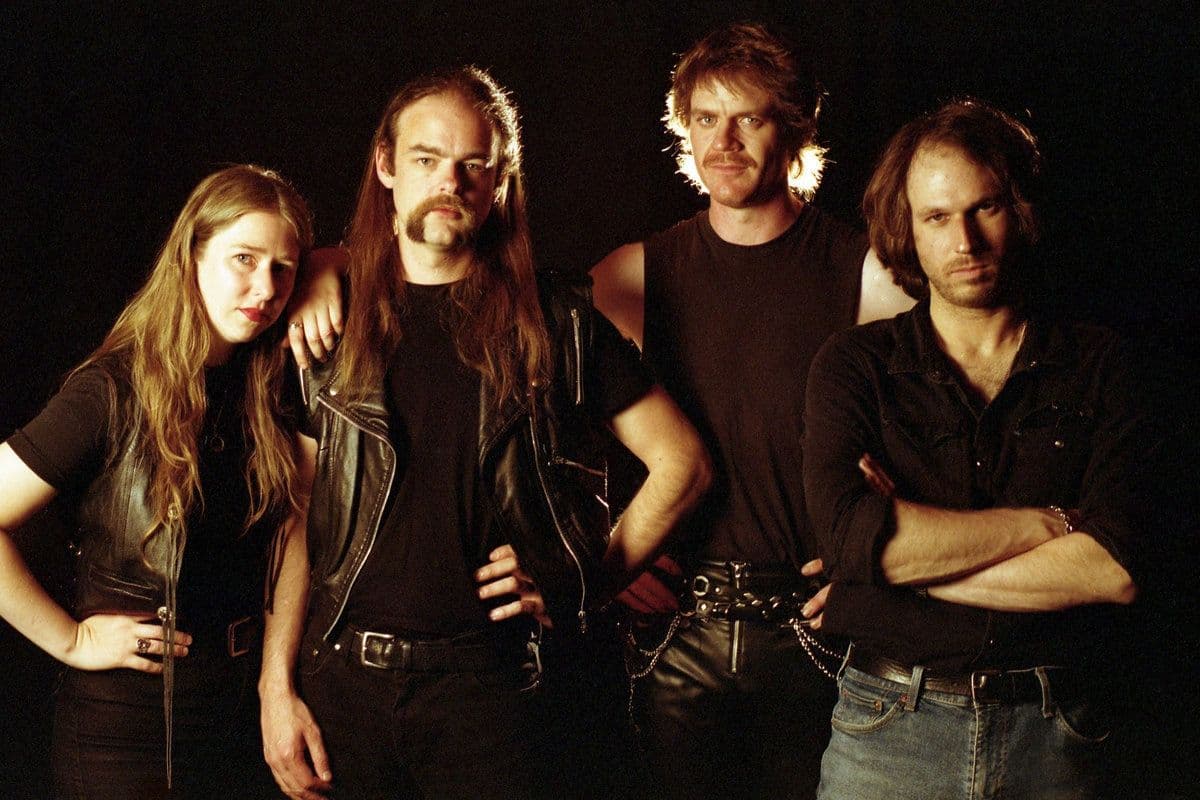 A group of people in metal stage costume with a black background